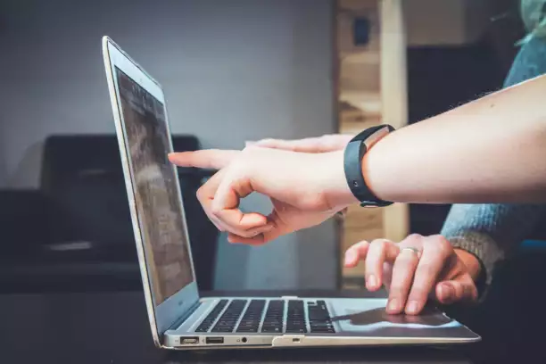 Deux personnes travaillent ensemble sur un ordinateur portable : l'une montre l'&eacute;cran du doigt tandis que l'autre tape au clavier. L'ambiance est studieuse et collaborative, ce qui t&eacute;moigne d'un bon esprit d'&eacute;quipe.